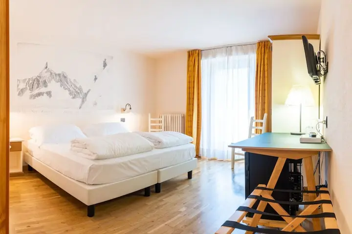 Superior Double Room at the Berthod, with twin beds, a desk and a balcony door